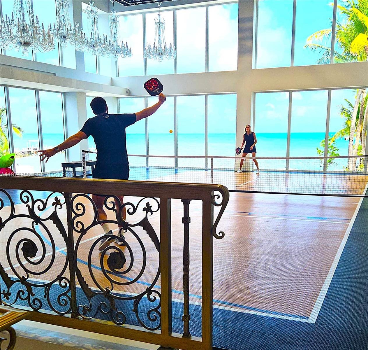 Indoor pickleball court with ocean views through floor-to-ceiling windows at The Chateau on the Ocean